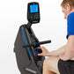 Man in blue shirt using black Horizon rowing machine with blue accents and digital display screen