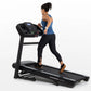 Woman running on black Horizon T202 folding treadmill with digital display, wearing blue tank top and black leggings