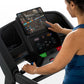 Black Horizon T202 folding treadmill with touchscreen display, worn by model in blue tank top on white background