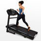 Woman running on black Horizon T202 folding treadmill with blue digital display, worn on white background