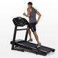 Man running on black Horizon T202 folding treadmill with digital console display against white background