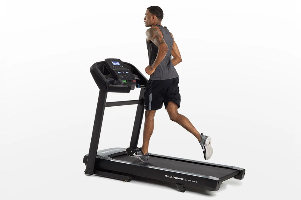 Man running on black Horizon T202 folding treadmill with digital console, shown in profile on white background