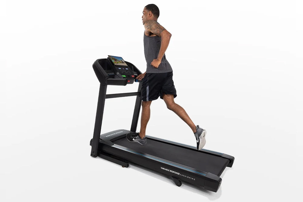 Man running on black Horizon T202 folding treadmill with digital display, wearing gray tank top and black shorts