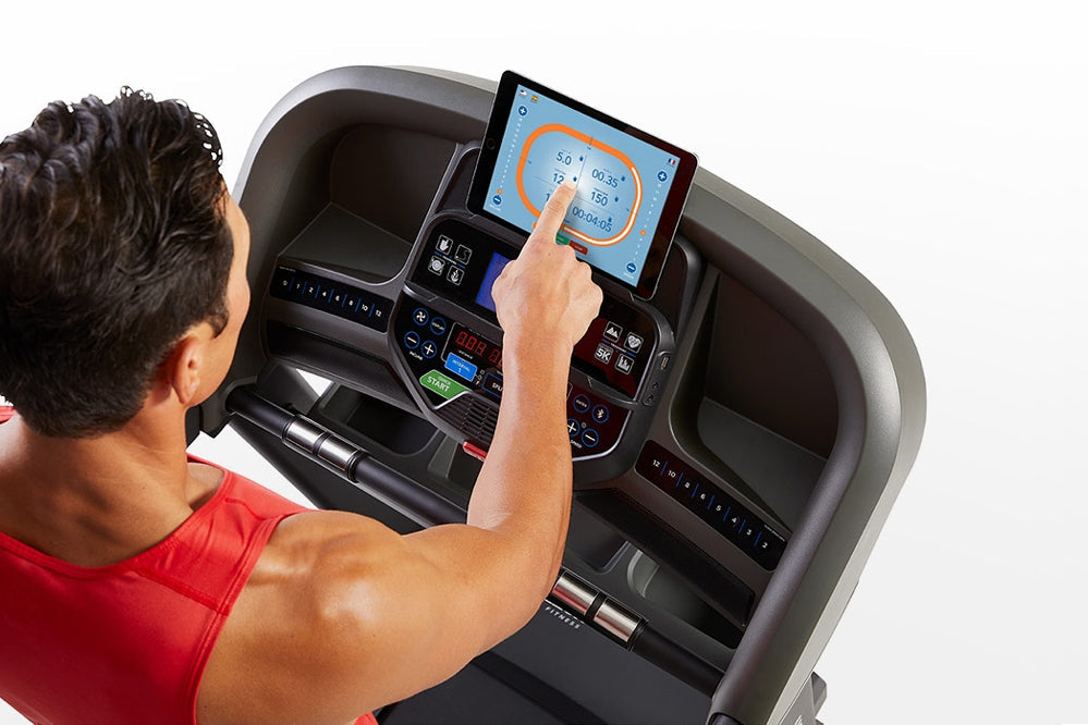 Man in red shirt using Horizon T303 folding treadmill with touchscreen display showing workout metrics