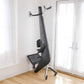 Black and gray Hydrow Origin rowing machine with digital display, footrest, and handle arms, positioned in home interior with