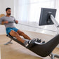 Man using black and silver Hydrow Origin rowing machine with digital monitor in bright home gym setting