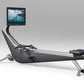 Black and silver rowing machine with articulating seat, adjustable footrest, and mounted tablet display showing water animati