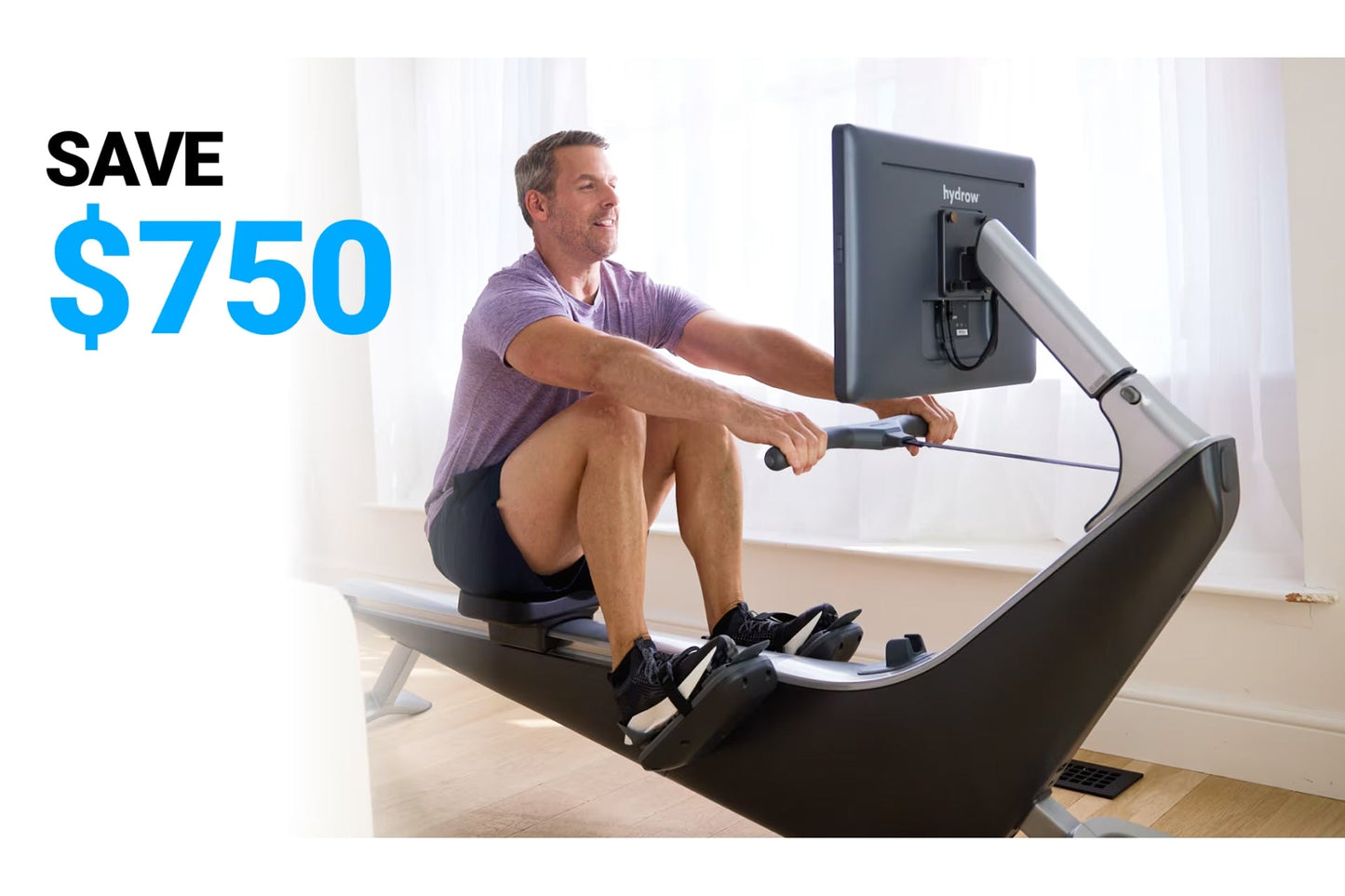 Man in purple shirt using black and white Hydrow Pro rowing machine with digital screen display