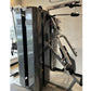Black and gray two-stack multi-gym machine with weight stack, cables, and pulleys in showroom setting
