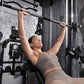 Woman in gray sports bra and leggings performing pull-up on black Inspire Fitness FT2 Pro Smith functional trainer in gym set