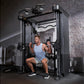 Man using black dual-pulley functional trainer machine with cable attachments in gym setting against brick wall