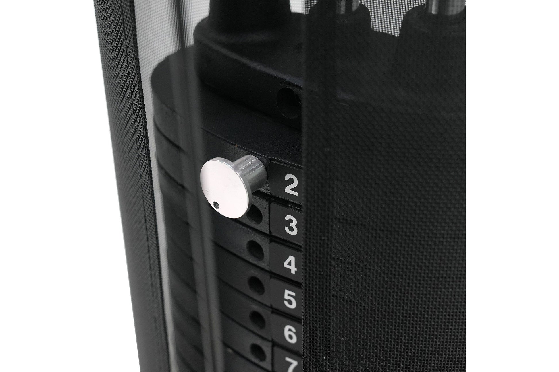 Black multi-gym system with white circular knob and numbered selector buttons 2-7, detail view on white background
