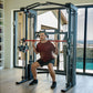 Man in burgundy t-shirt and black shorts using black Smith functional trainer with red bar in modern home gym with ocean view