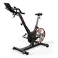 Black and red stationary exercise bike with padded seat, curved handlebars, and red flywheel on white background