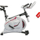 White and black stationary exercise bike with red accents, adjustable handlebars, and digital display, shown on white backgro