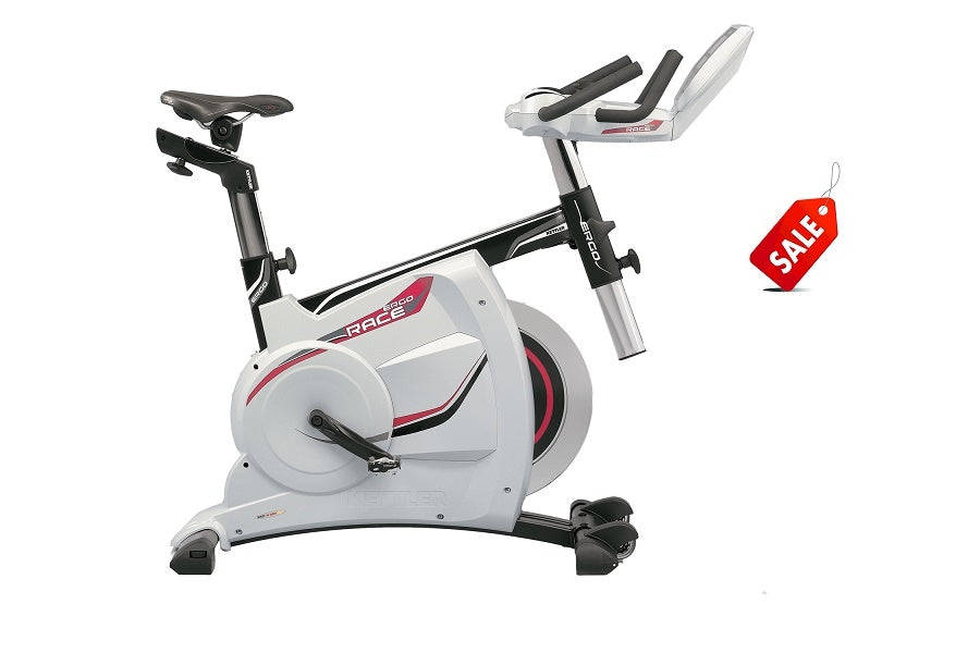 White and black stationary exercise bike with red accents, adjustable handlebars, and digital display, shown on white backgro