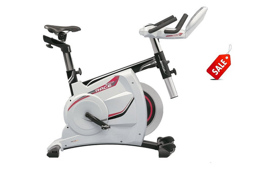 White and black stationary exercise bike with red accents, adjustable handlebars, and digital display, shown on white backgro