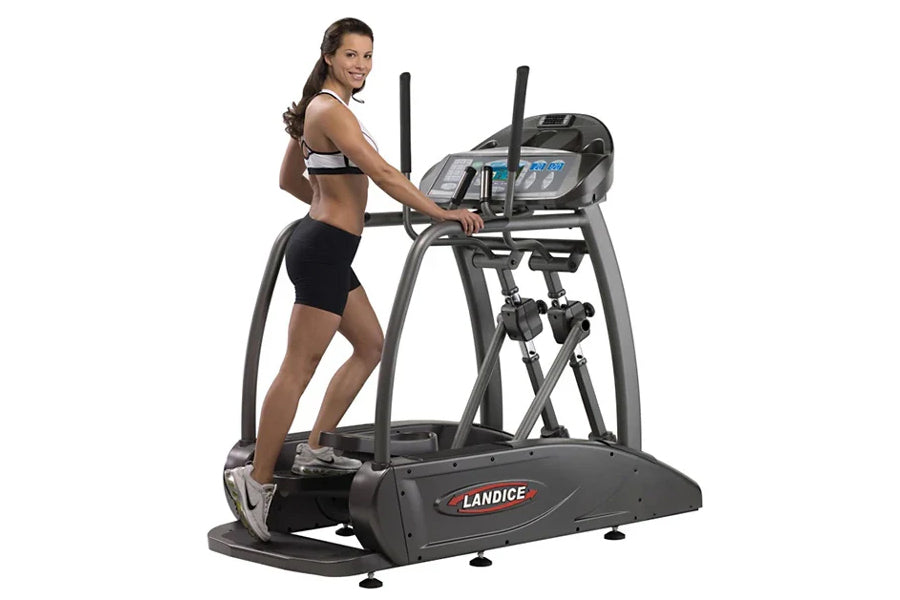 Woman using black Landice E7 elliptical machine with digital display and dual handles on white background