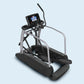Landice E9 commercial elliptical with black foot pedals, gray frame, digital console, and safety handrails on light blue back
