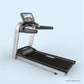 Silver and black commercial treadmill with digital touchscreen display, black running belt, and cushioned handles on light bl