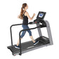 Woman running on black and gray Landice L7 treadmill with digital display console, worn by model on white background