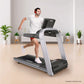 Man running on silver and black Landice L7 treadmill with digital display, wearing white t-shirt and red headphones in home g