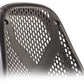 Black mesh backrest with perforated ventilation pattern and molded contours, front view on white background