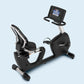 Black and silver recumbent exercise bike with digital display console and padded seat, on light blue background