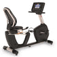 Landice R9 black recumbent exercise bike with digital display console, mesh backrest, and pedal resistance system on white ba