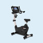 Landice U7 upright exercise bike with black frame, beige center post, digital console display, and foot pedals on light blue 