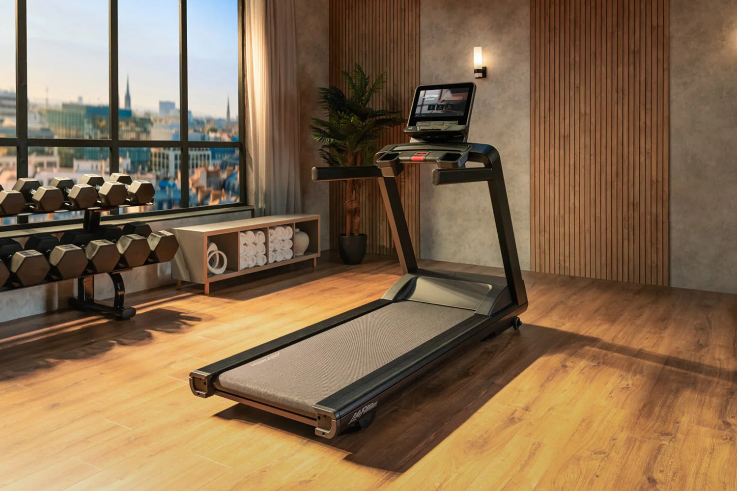 Black Life Fitness Atmos treadmill with digital display in modern gym setting with city skyline view