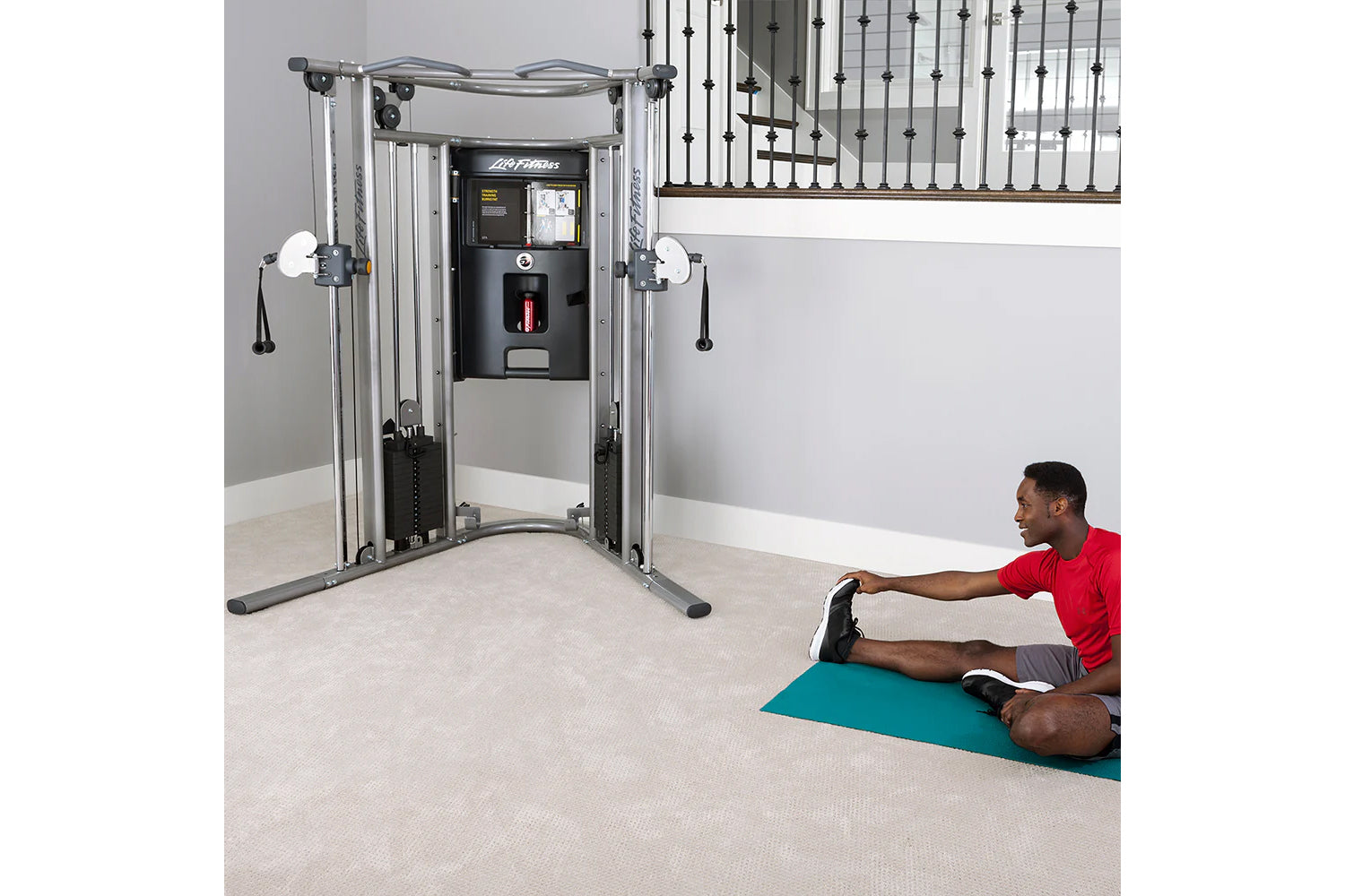 Life Fitness G7 functional trainer with dual cable towers and black control center, model demonstrating use on teal mat in ho