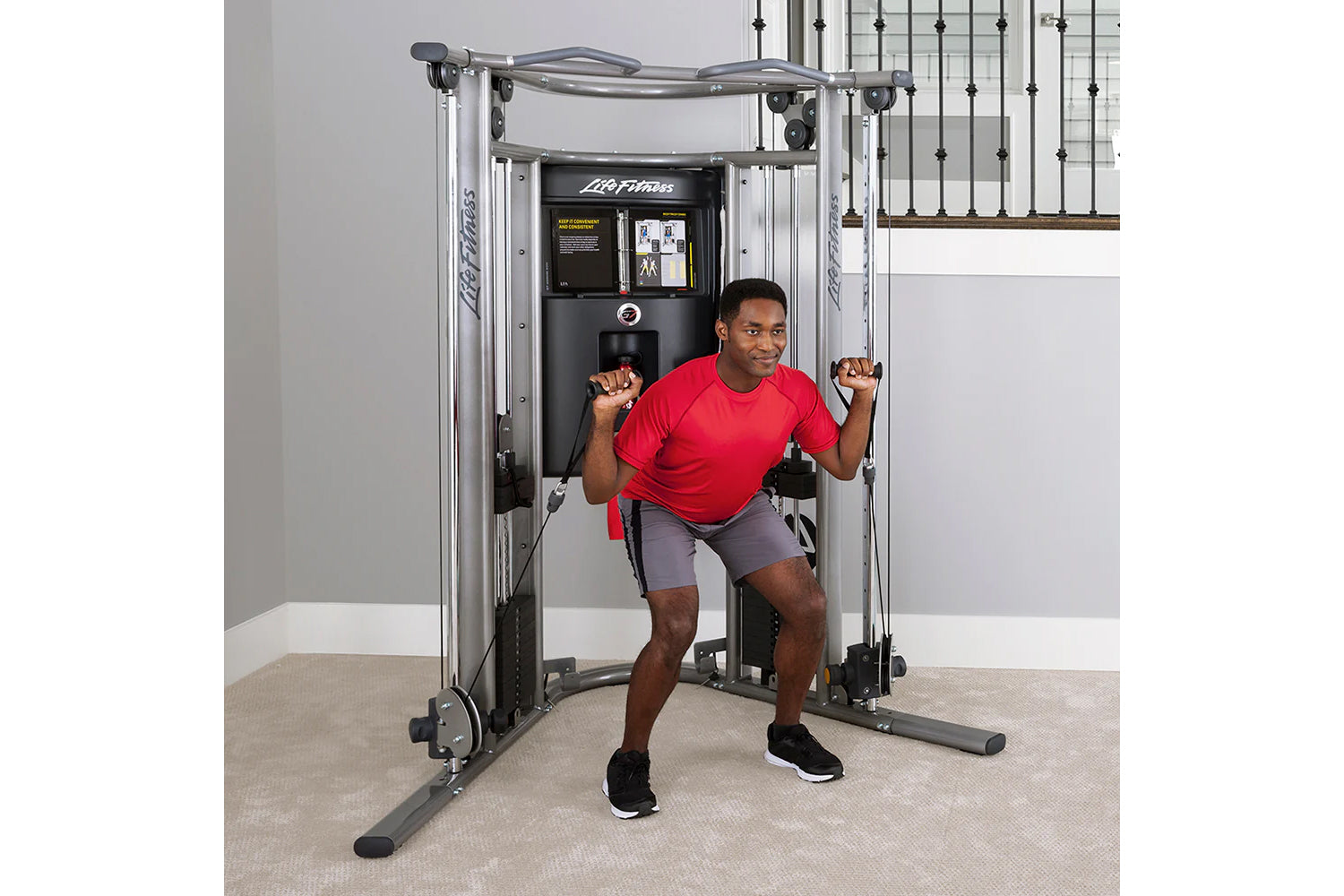Life Fitness G7 home gym with silver frame and black console, man in red shirt using cable pulleys for exercise