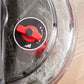 Red and black water rower damper control dial with white icon, mounted on clear water tank with water droplets visible