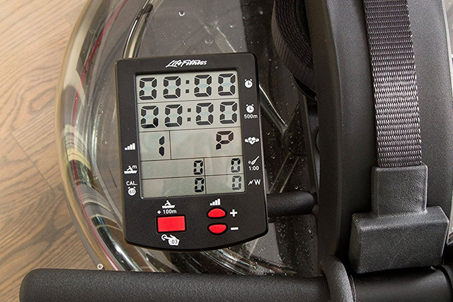 Black digital monitor display mounted on water rower showing dual time readouts, distance, heart rate, and control buttons wi