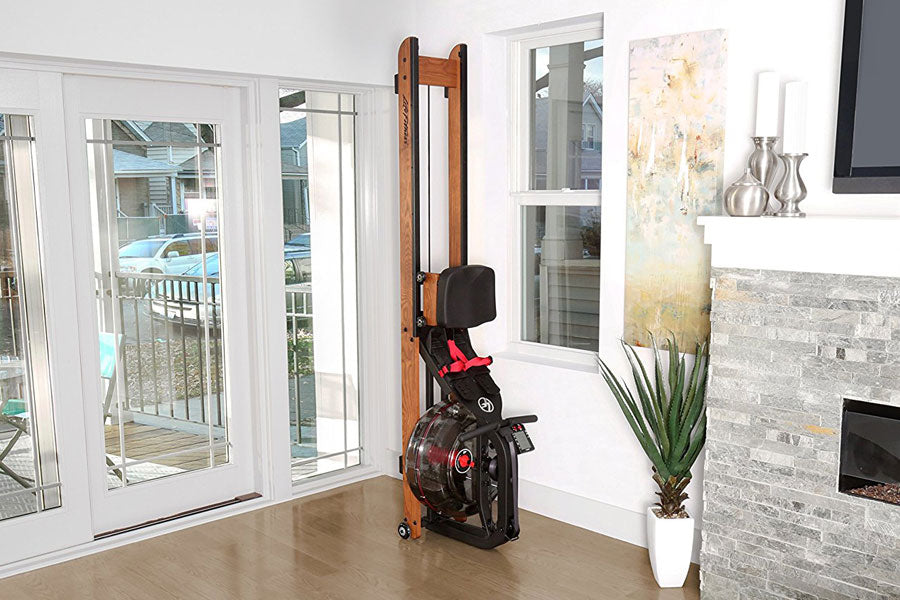 Life Fitness HX water rowing machine with wooden frame, black seat, and red accents in home fitness room setting