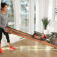 Woman using wooden water rower with red accents in bright home gym space with glass doors