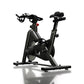 Black indoor stationary bike with curved drop handlebars, adjustable seat, and digital console on white background