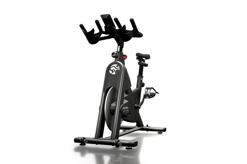 Black and gray stationary indoor exercise bike with padded seat, handlebars, and pedals on white background