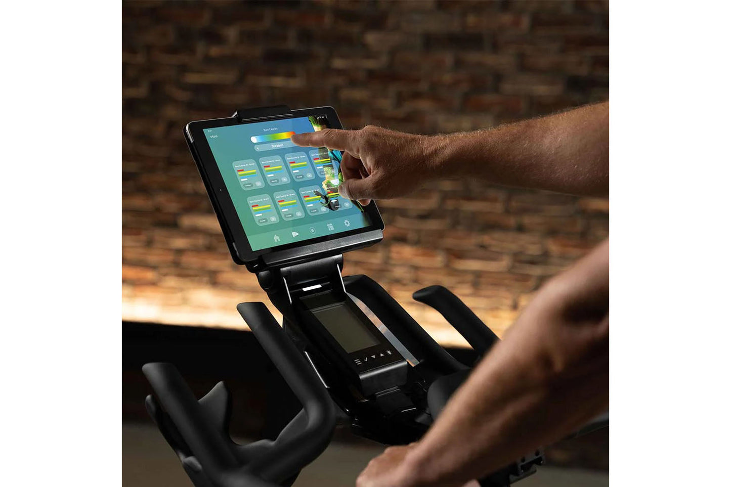 Person using a tablet on a piece of exercise equipment