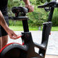 Person adjusting a black exercise bike