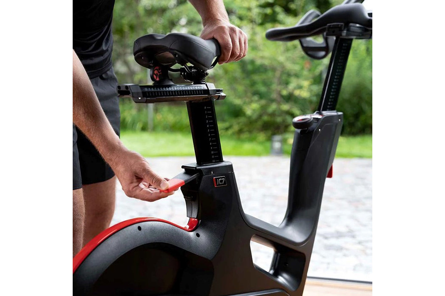 Person adjusting a black exercise bike