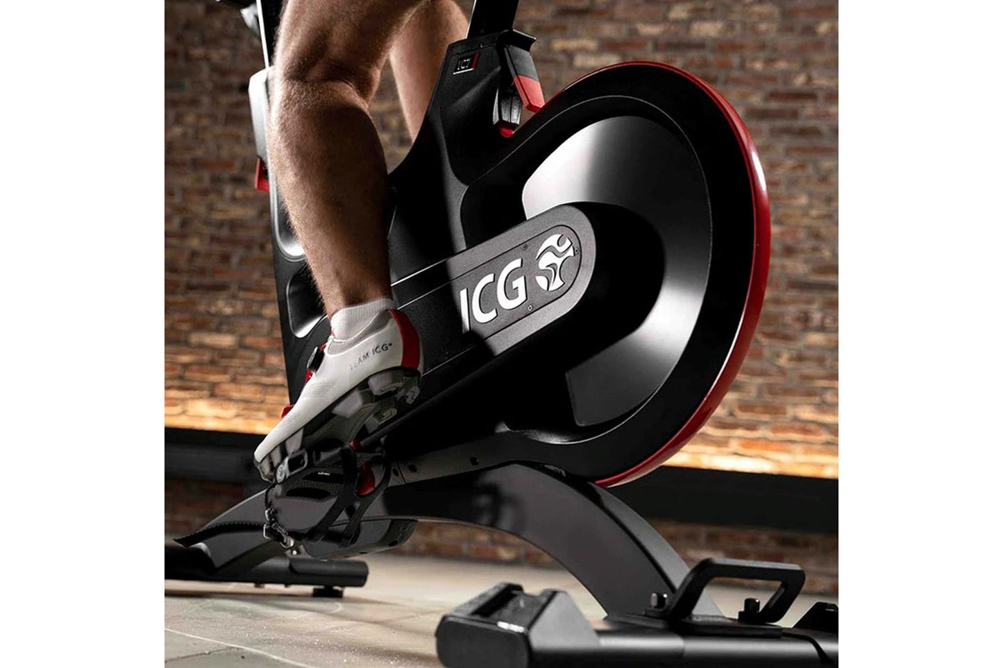 Person using a stationary bike with ICG branding in a home setting.