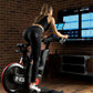 Woman exercising on a stationary bike in front of multiple screens in a room