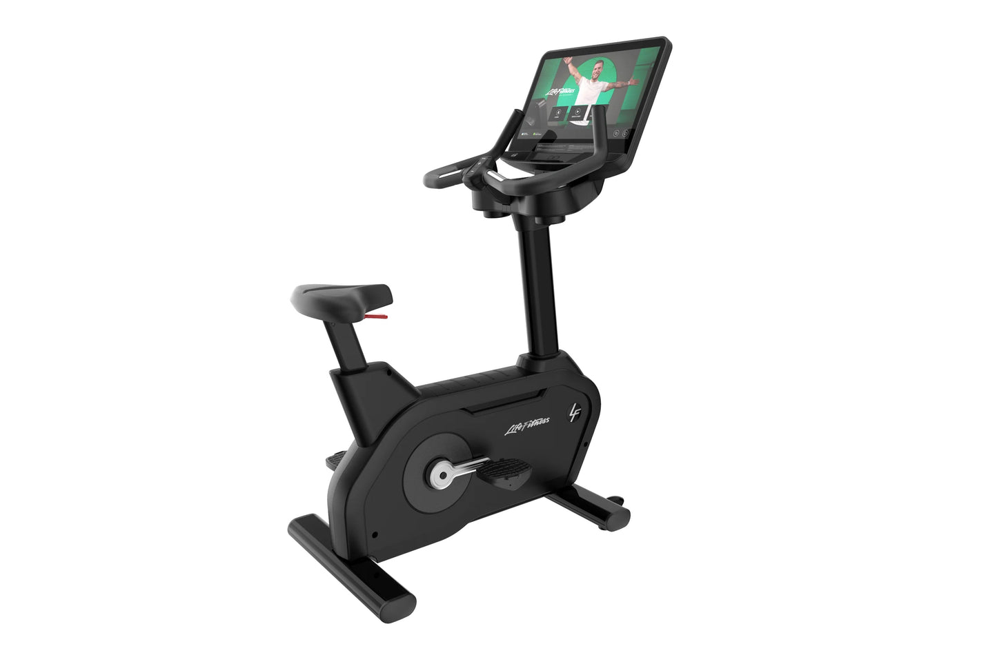Black upright exercise bike with digital touchscreen display showing fitness class, padded seat with red accents, and stable 