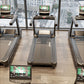 Row of Life Fitness Integrity+ treadmills with gray frames and touchscreen displays in high-rise gym with city views