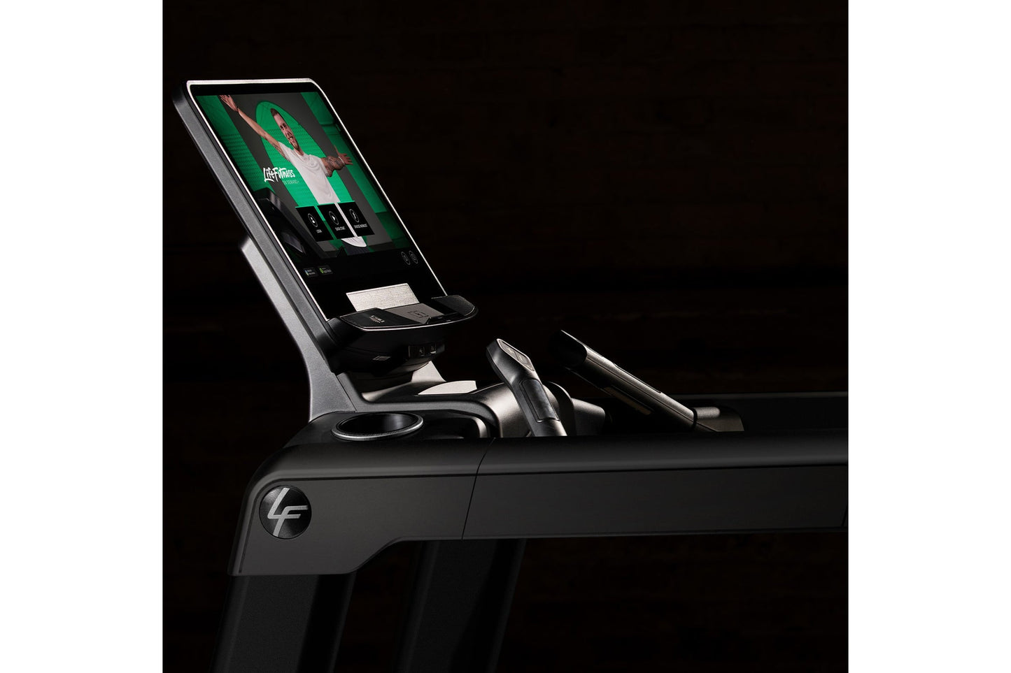 Life Fitness Integrity+ treadmill with digital display console and black frame on black background