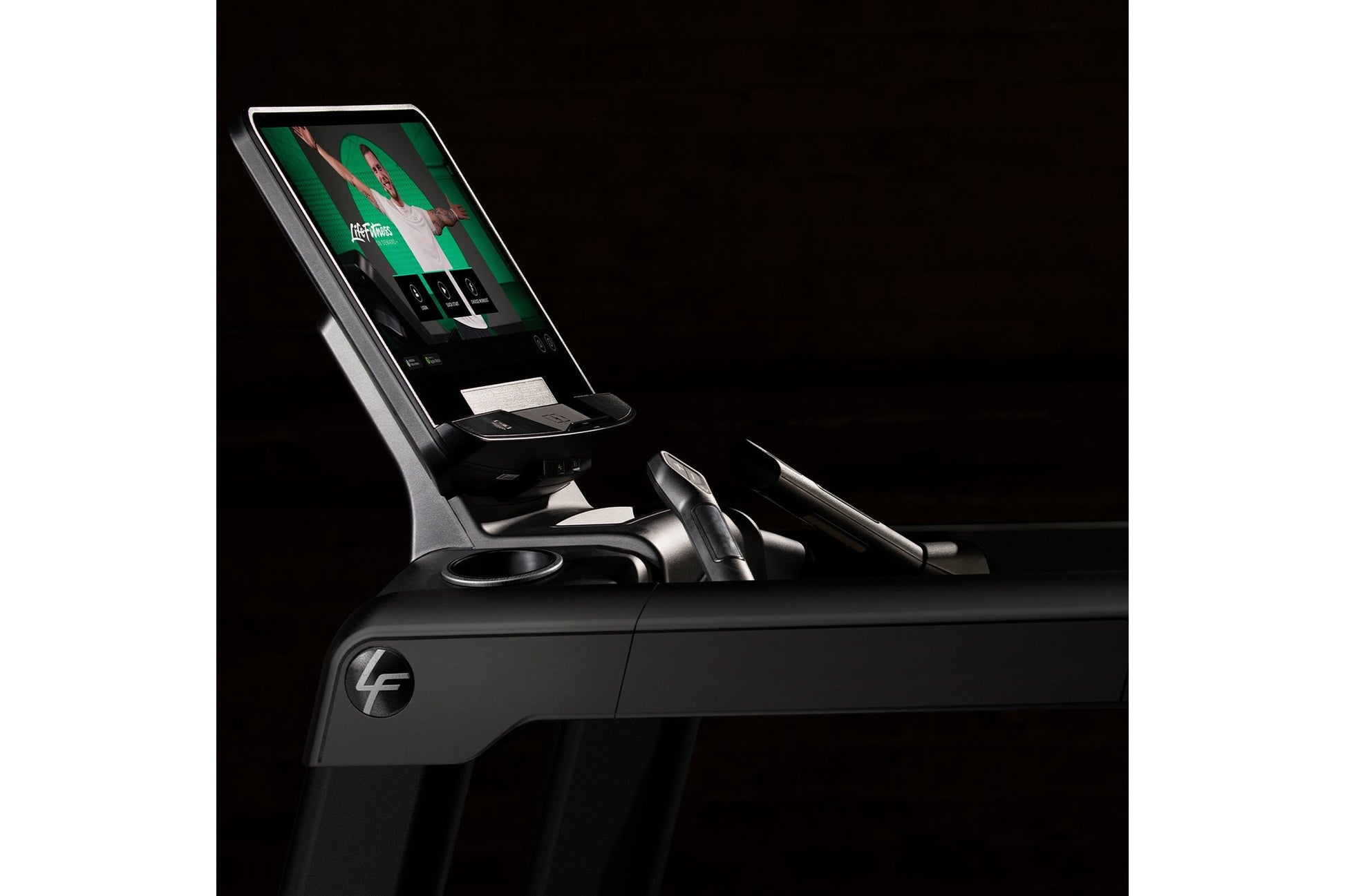 Life Fitness Integrity+ treadmill with digital display console and black frame on black background