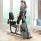 Woman using gray and black Life Fitness RS1 recumbent exercise bike with digital display in bright home gym setting