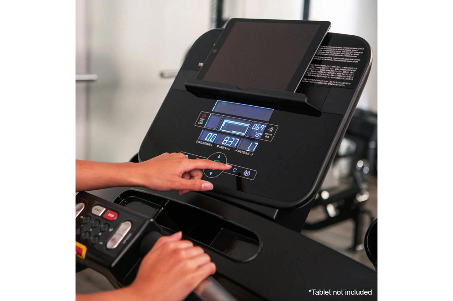Black Life Fitness Run CX treadmill console with blue digital display showing metrics, operated by user hands in gym setting